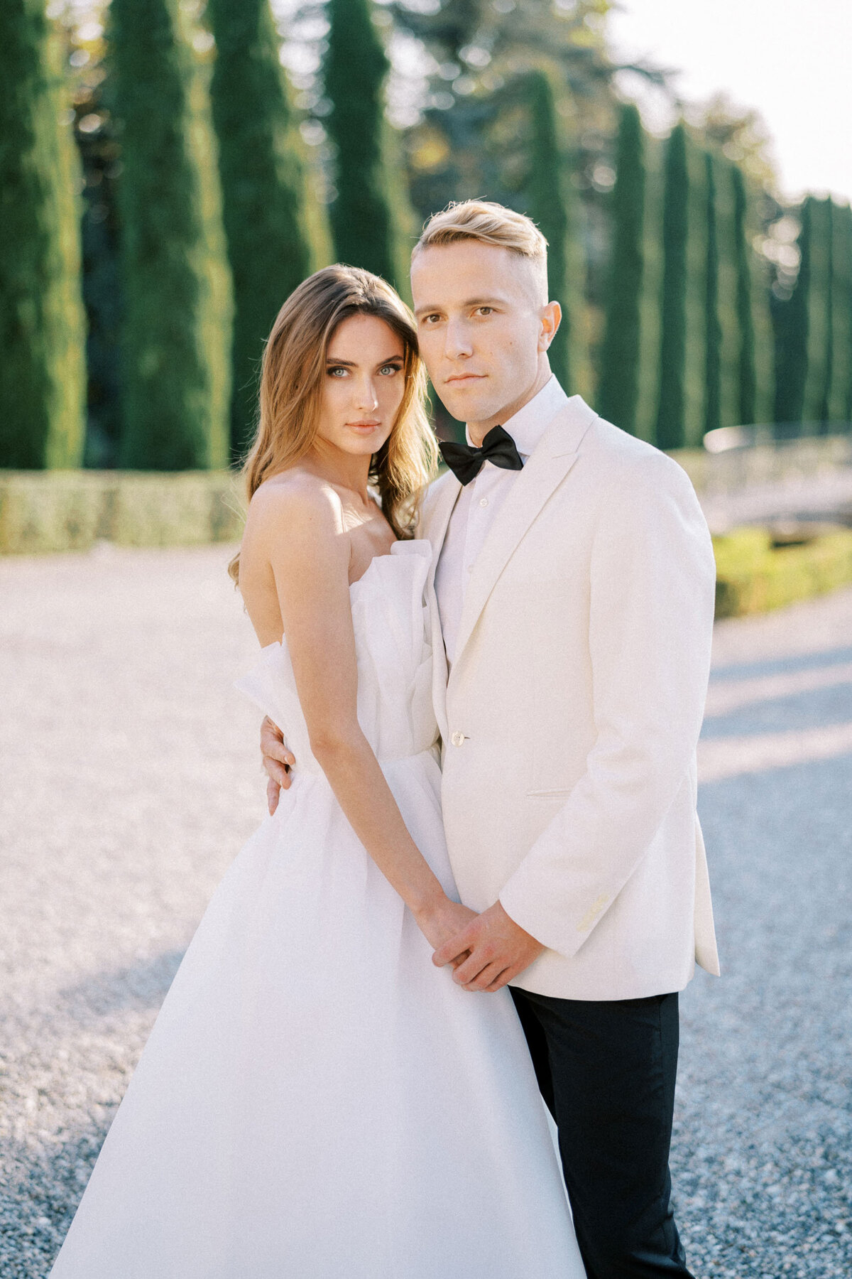 Elegant bride and groom in white attire posing during a stylish outdoor wedding, captured by Toronto wedding photographer Nadtochiy