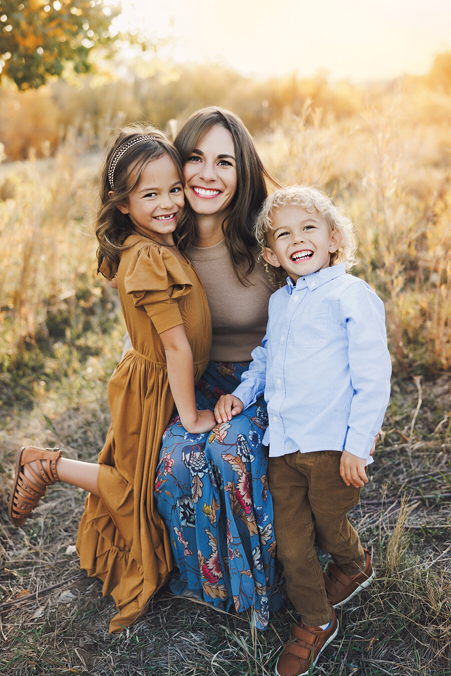 Mom poses for fall family pictures with her two kids.