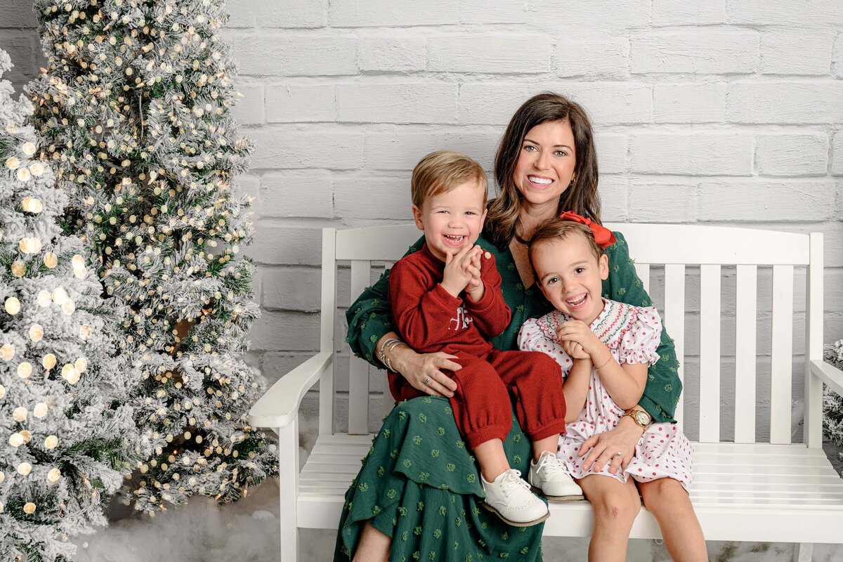 mother snuggles her two children during holiday mini session
