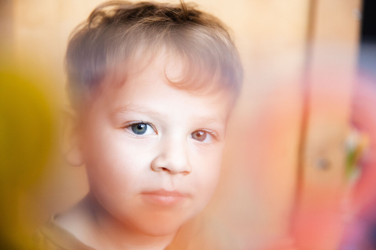 Artistic portrait of toddler boy looking at the camera.