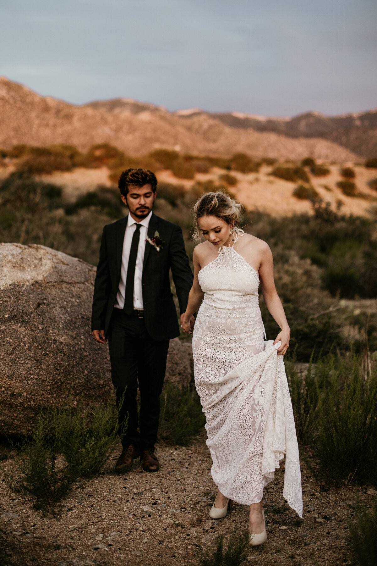 newlyweds walking in the desert