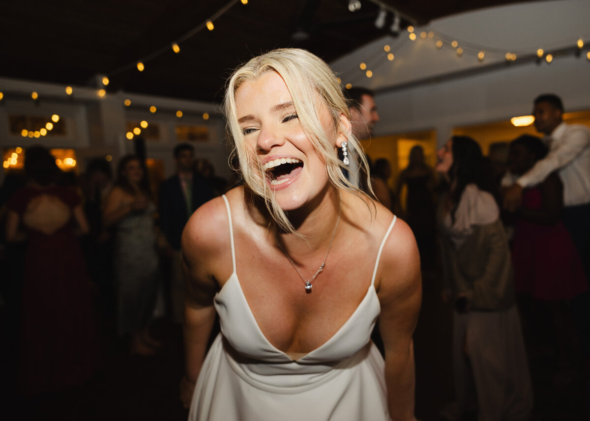 A close up of a wedding guests smiling at a reception 