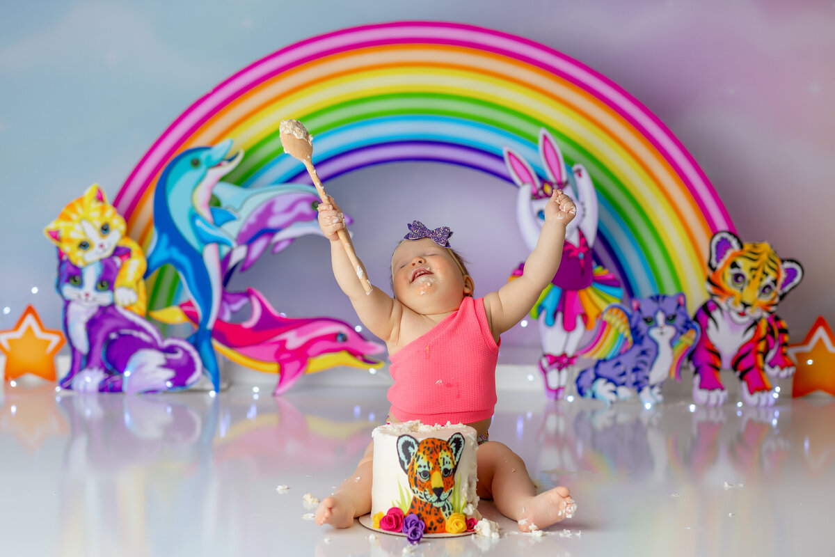 One year old Tampa baby enjoying a personalized luxury cake smash session with Lisa Frank decorations