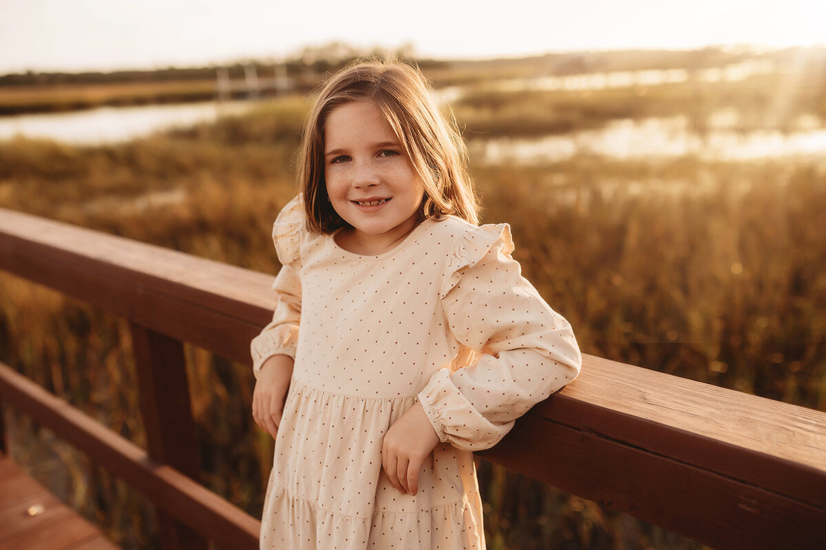 Little girls grins at the camera during Family Photo Session in Charleston, South Carolina.