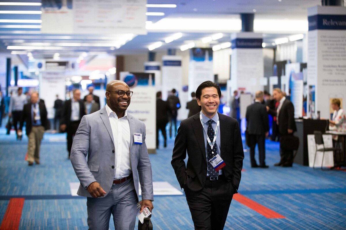 two doctors walk happily while in conversation at the Congress of Neurological Surgeons annual meeting