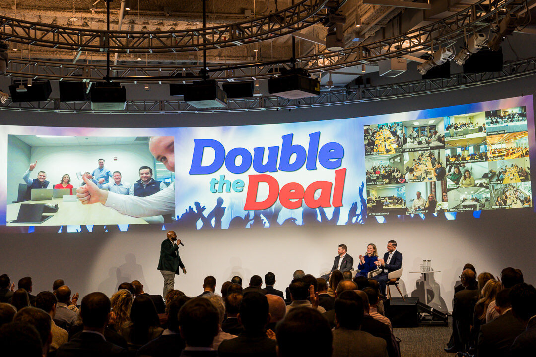Corporate event photography of keynote presenter addressing large audience with stage projection new jersey.