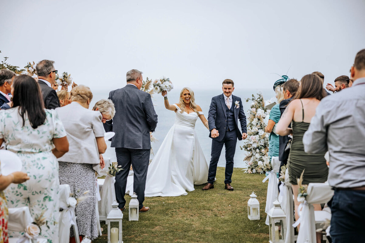 A bride and groom walking down the aisle after the ceremony