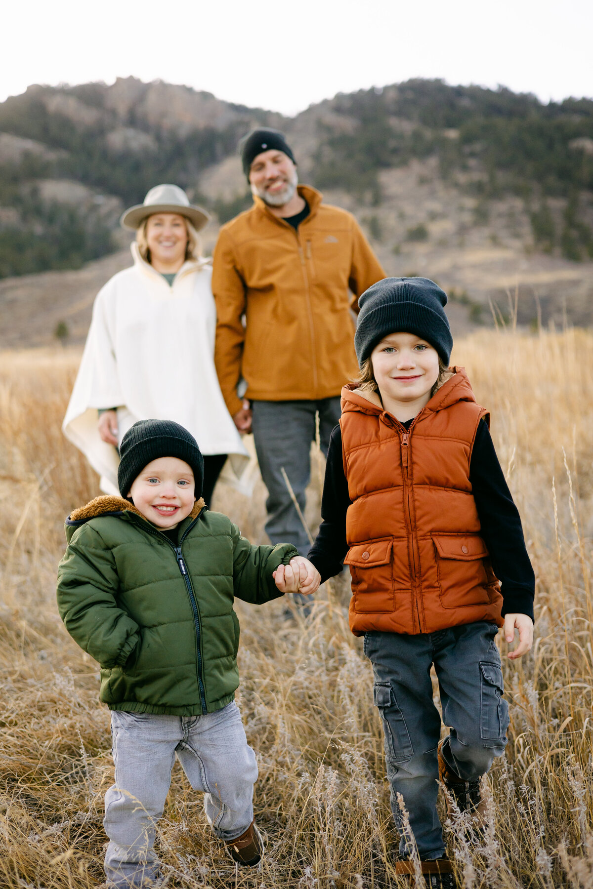 Two sons walk ahead of their parents during their family photoshoot in Fort Collins, Colorado.