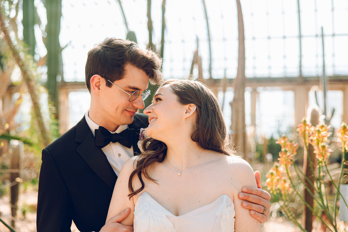 A couple poses on their wedding day at the Garfield Park Conservatory in Chicago