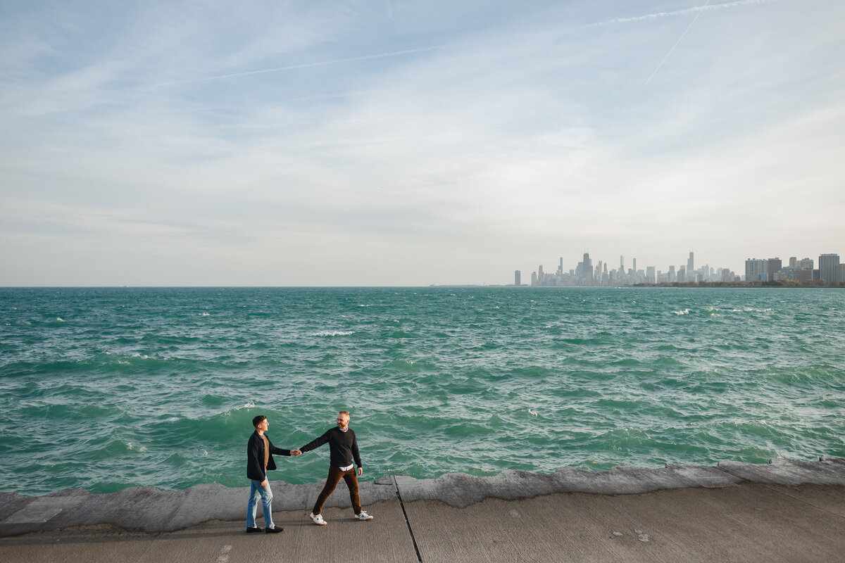 A couple holds hands while walking on the Chicago lakefront