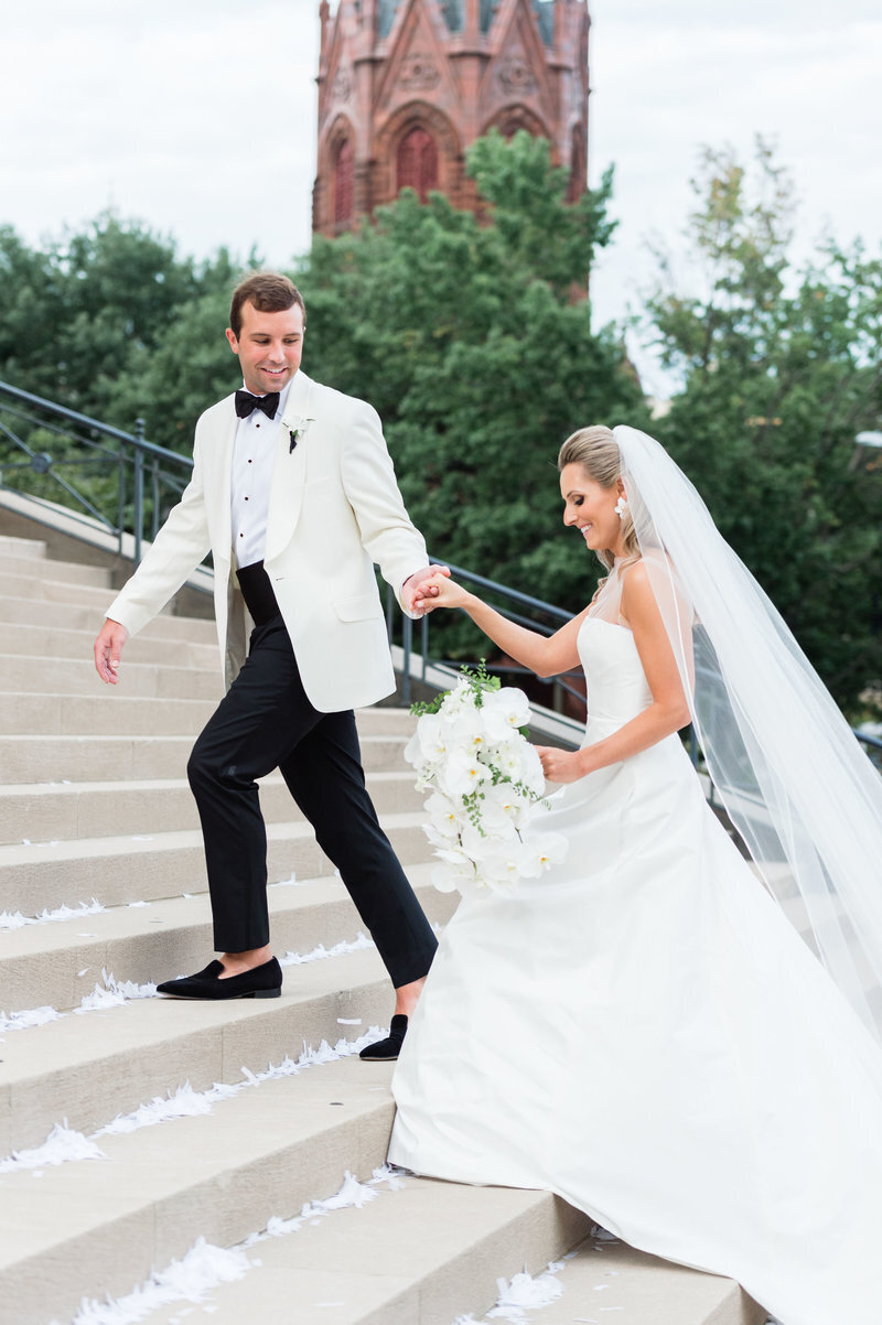groom-helping-bride-up-steps-national-city-chrisitian-church-dc