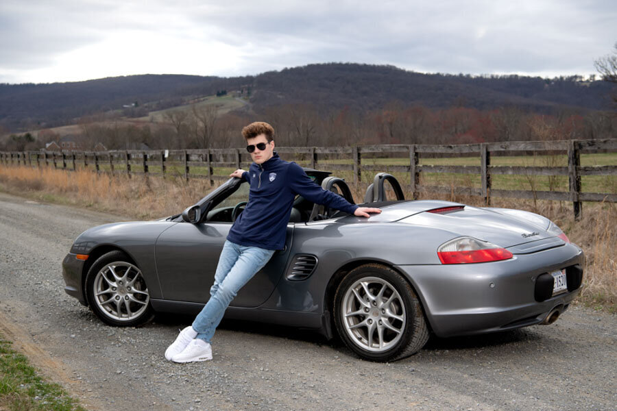 boy and porsche on country road