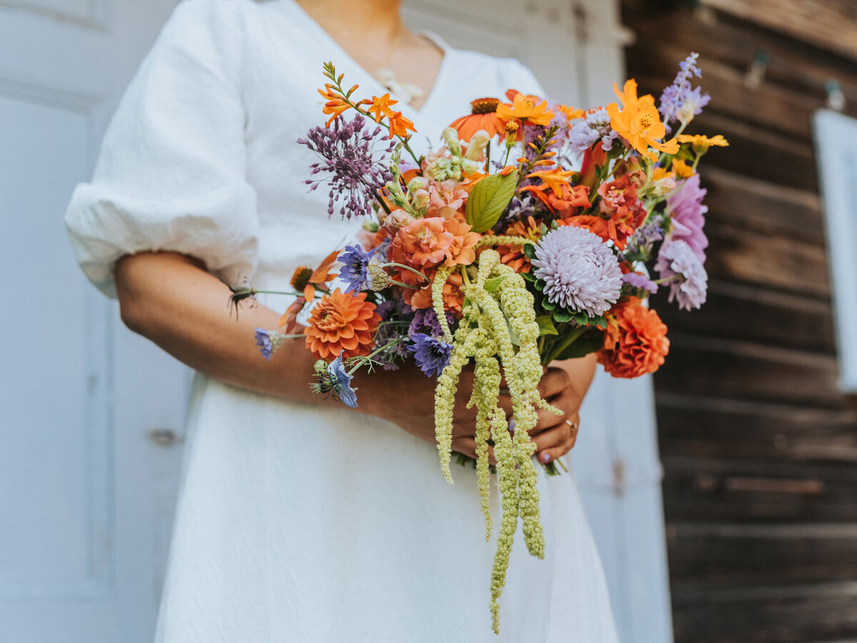 bride holding small summer flowers wedding bouquet  at her Starling Lane Vineyard wedding. Photo by MMiKO Weddings Photography - Fleuris Studio & Blooms