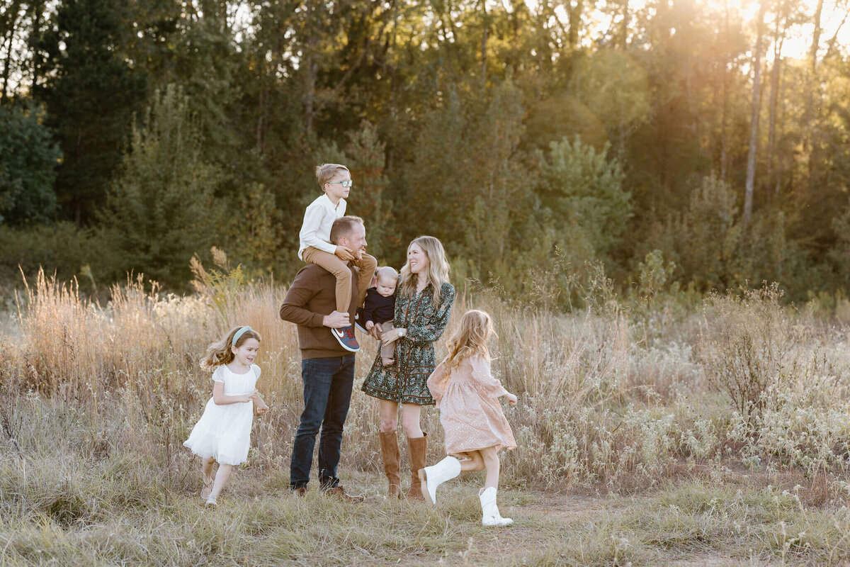 Longview, TX family playing in open field for fall family photos