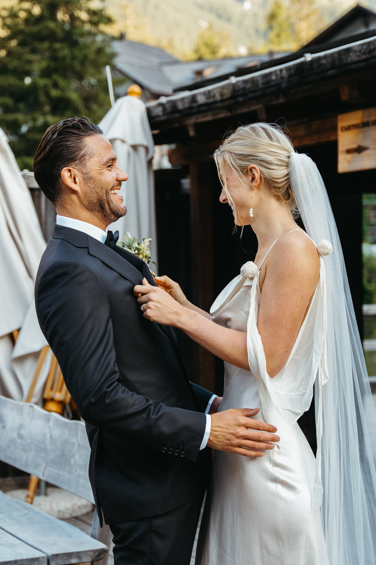 Bride and groom laughing during intimate moment on dock