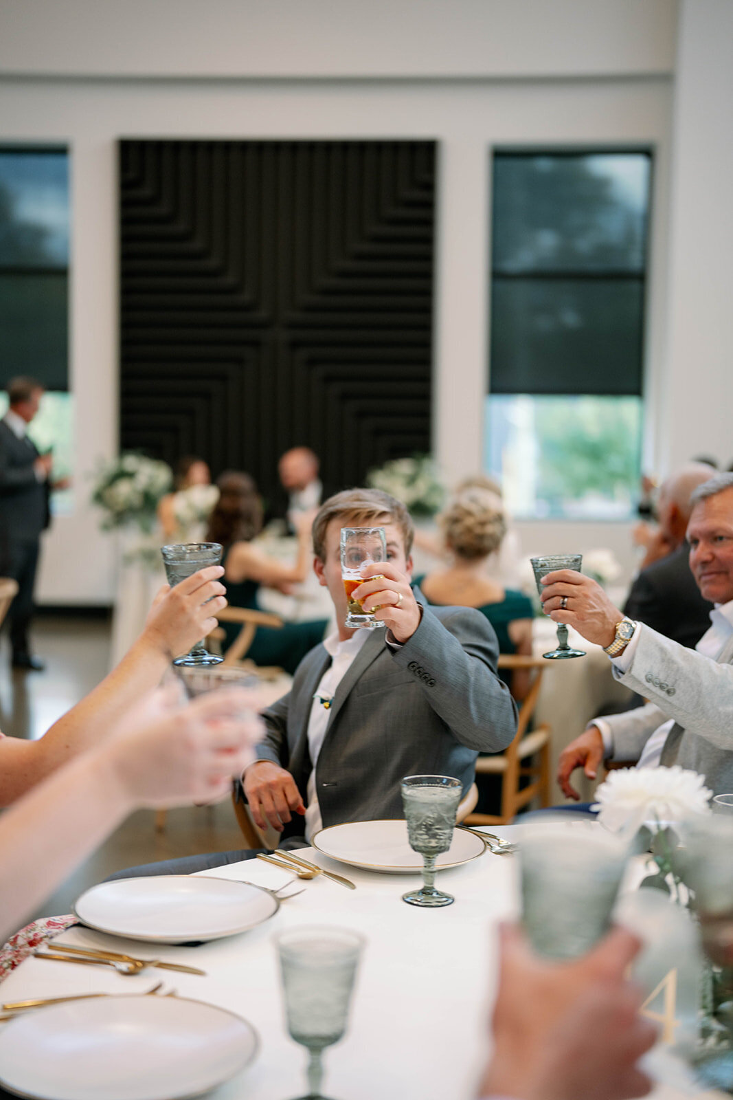 Guests raising glasses and toasting the newlyweds during their Leona Road wedding reception in Grand Rapids, Michigan.