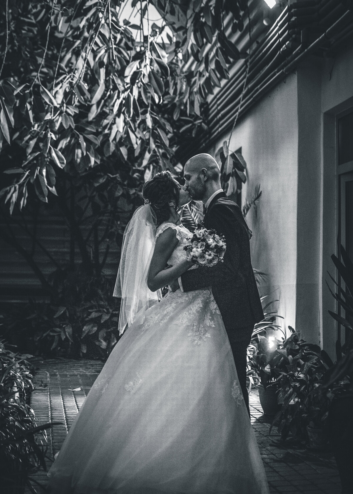 A black and white image of a bride and groom kissing on their wedding day in Italy.
