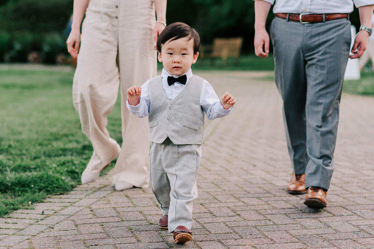 a child exploring Green Spring Gardens as his parents watch on dutifully