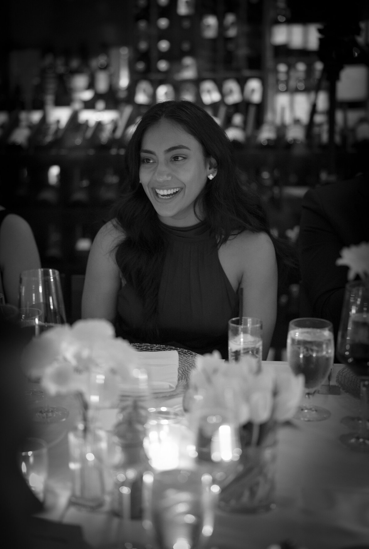 Wedding guests smiles, illuminated by candles during wedding reception.