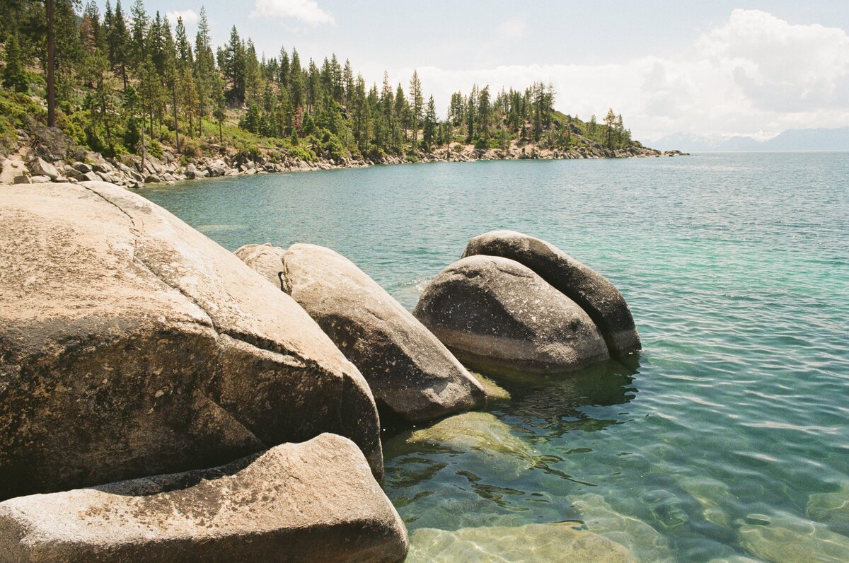 lake tahoe nature shot focused on some rocks with water looking off into the distance