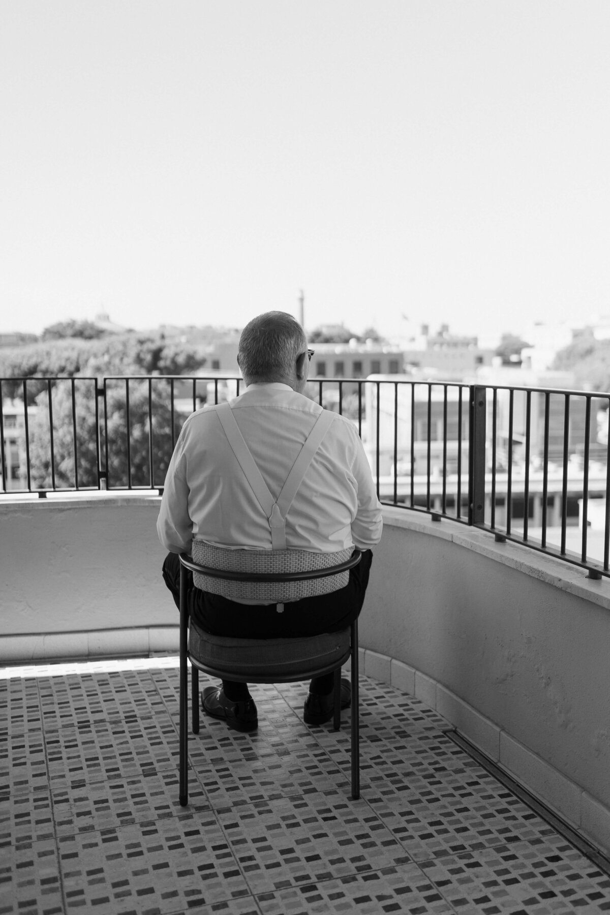 Groom sitting on balcony at Soho House Rome before the wedding ceremony