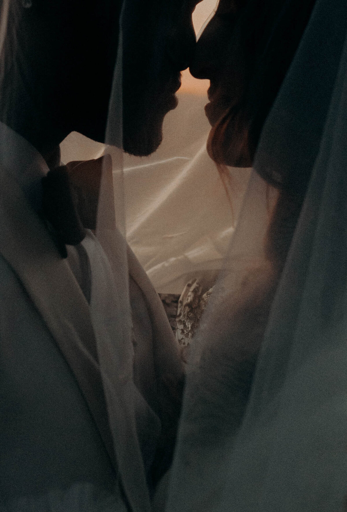 under the veil bride and groom moody portrait