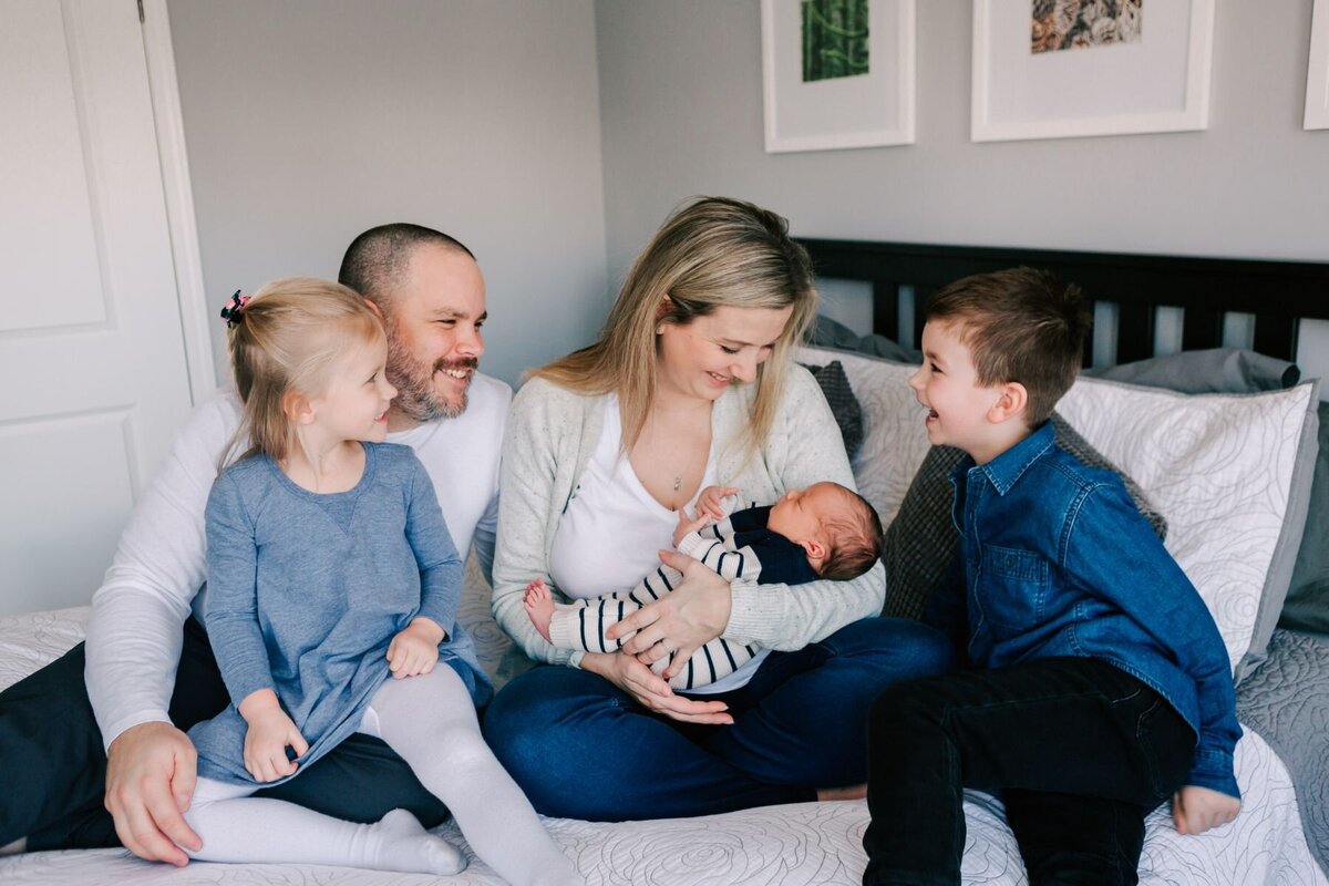 Family smiles at baby during the newborn session.