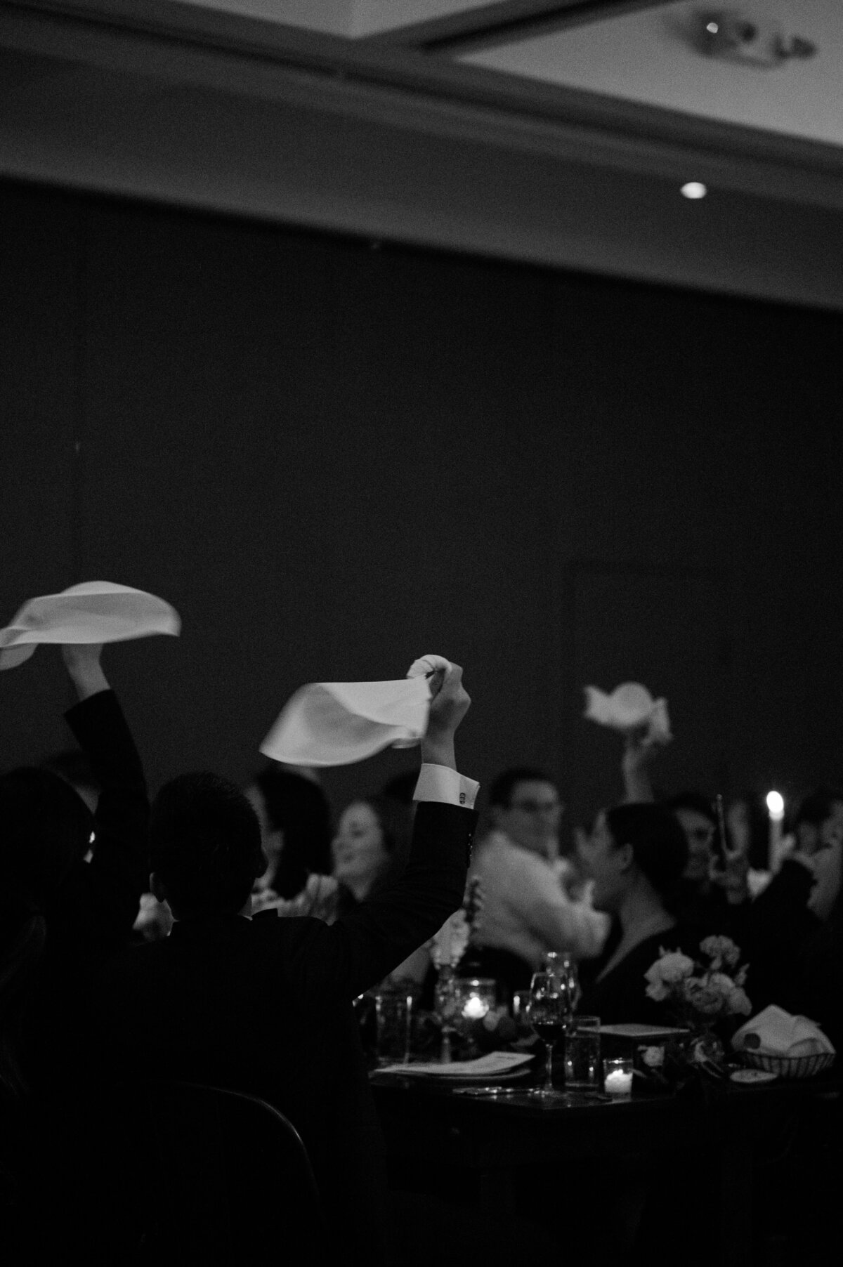 Wedding attendees wave their napkins in the air