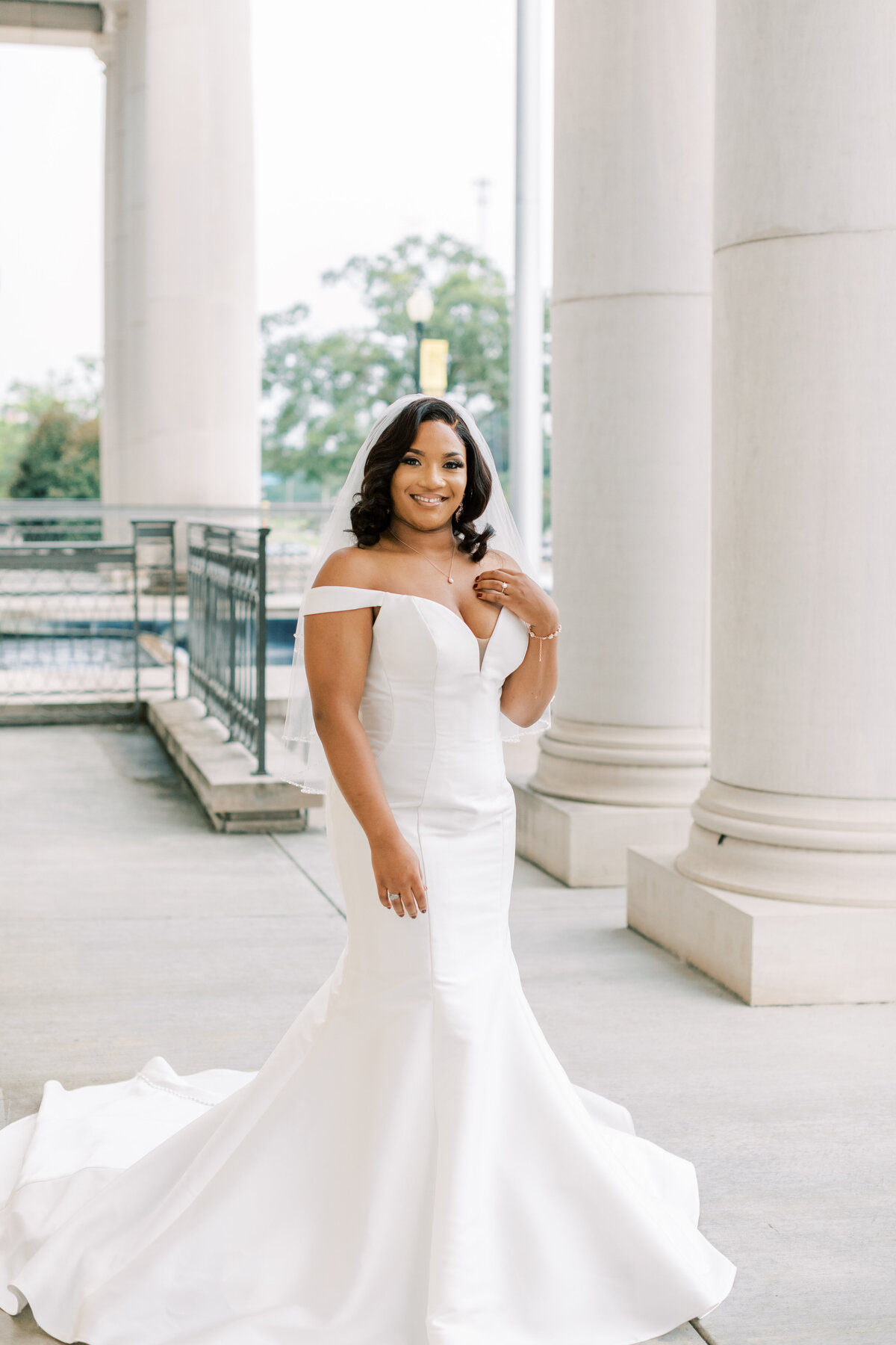 A bride stands by the columns at Southern Miss.