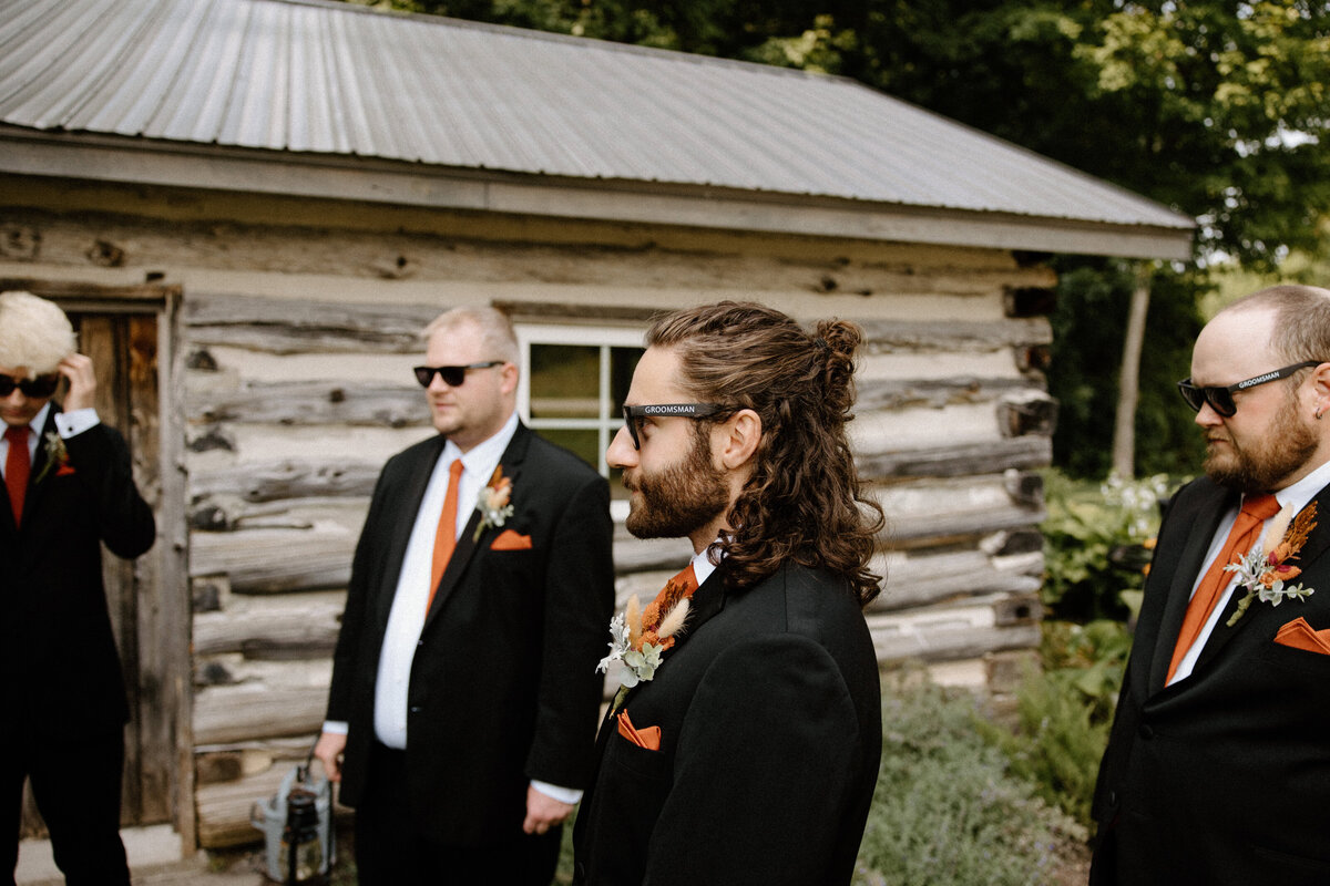 The groomsmen in shades, watching the groom's solo portraits
