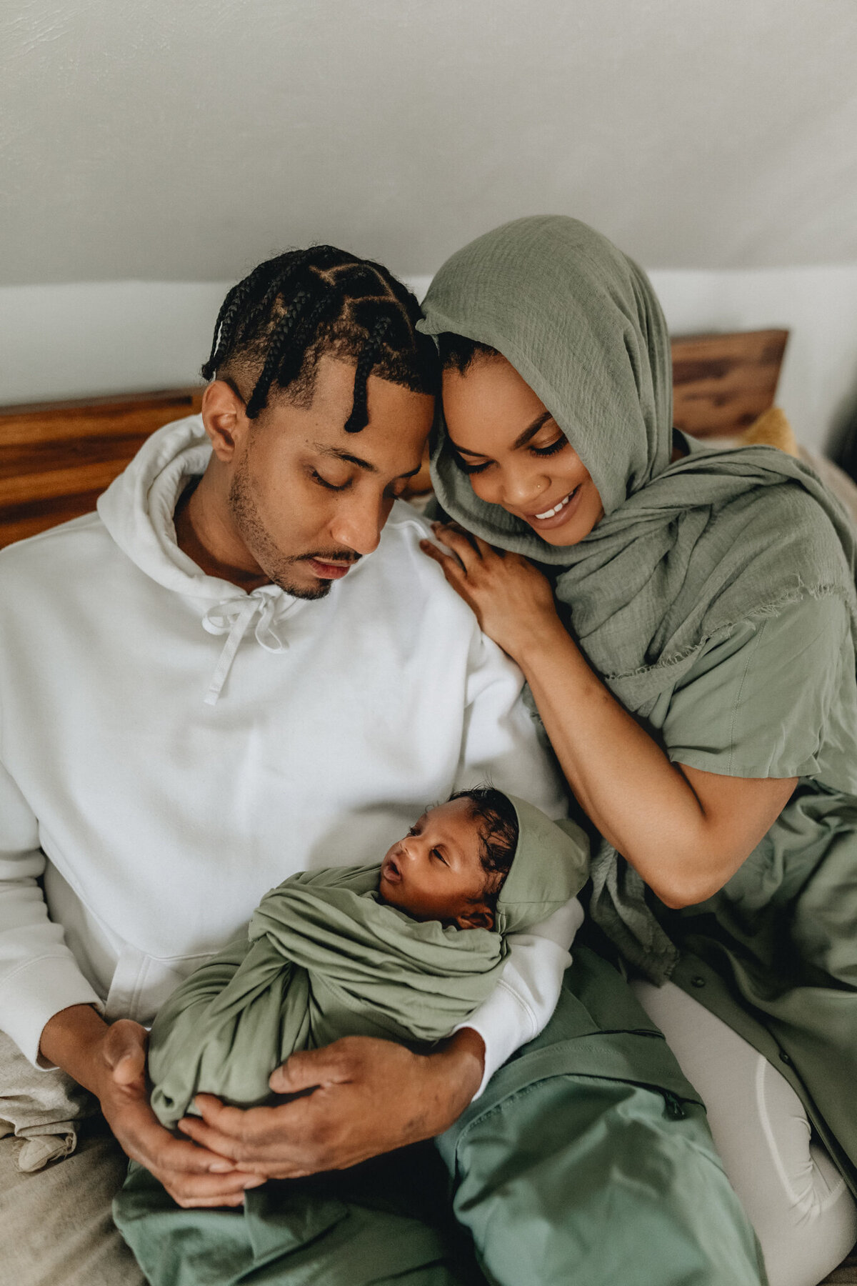 Infant photographer capturing a newborn baby being held by mom and dad.