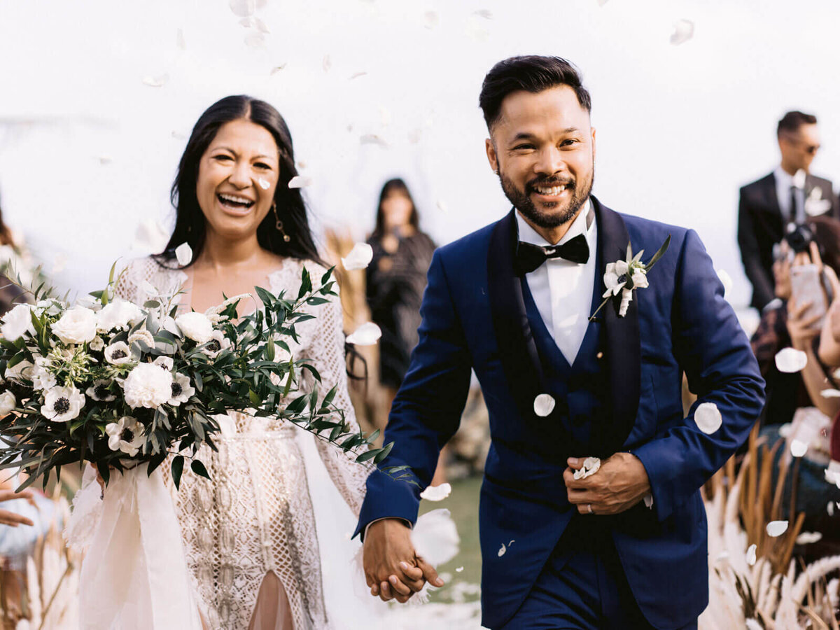 The bride and groom are happily walking back down the wedding aisle in Khayangan Estate, Bali, Indonesia. Image by Jenny Fu Studio