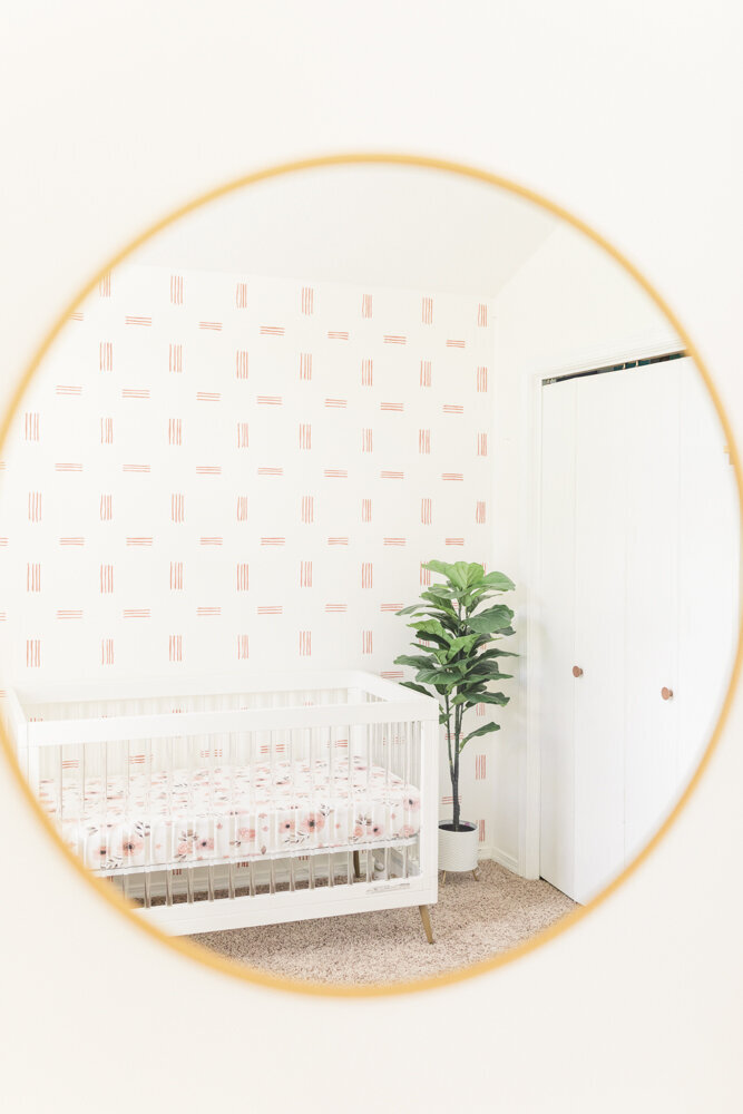 the reflection in a mirror showing a crib and other nursery details