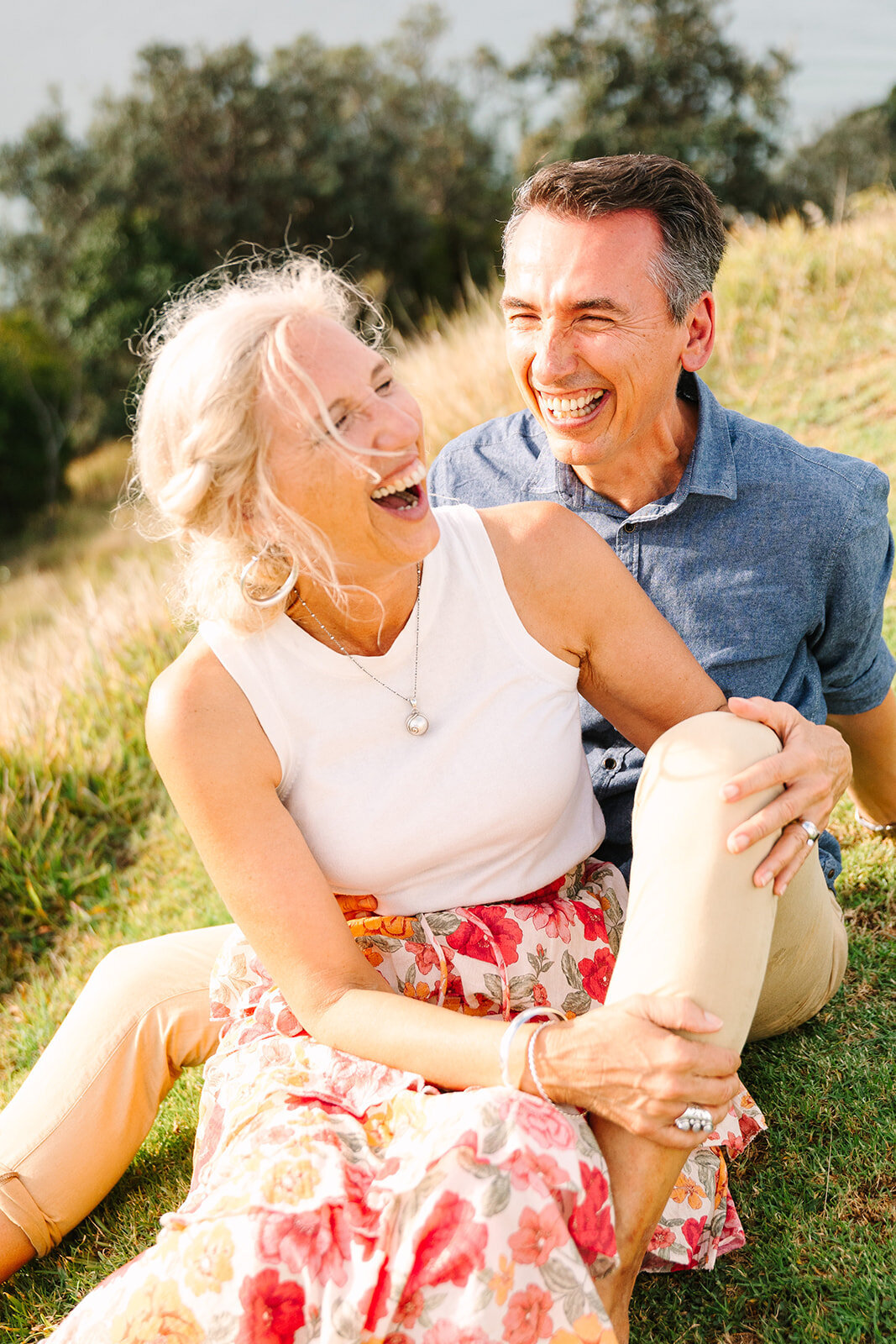 wife laughing with husband on the grass