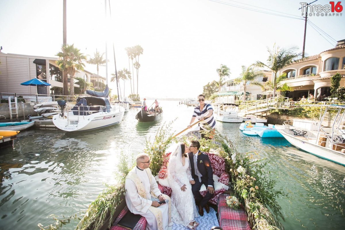 Bride and Groom share their first kiss on a gondola wedding