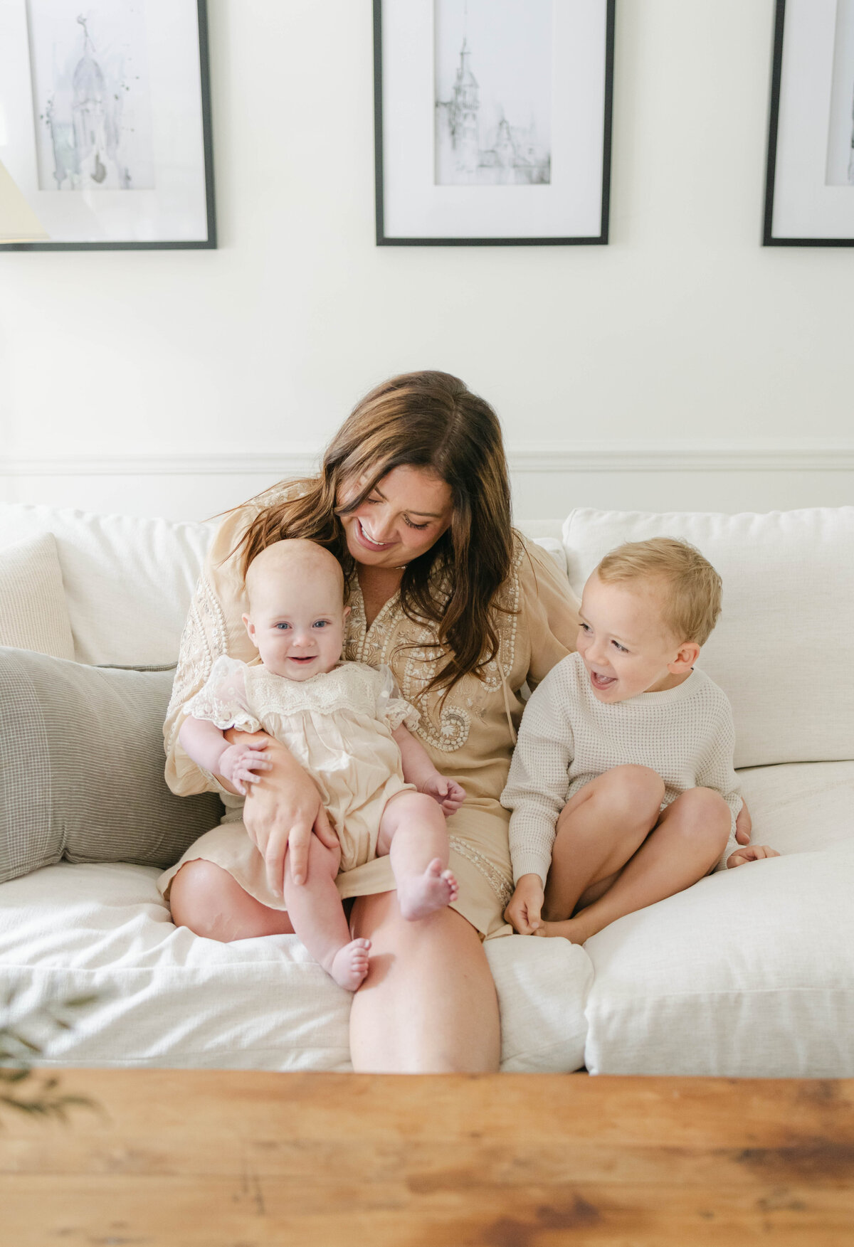 Mom sitting on couch with her toddler boy and baby girl