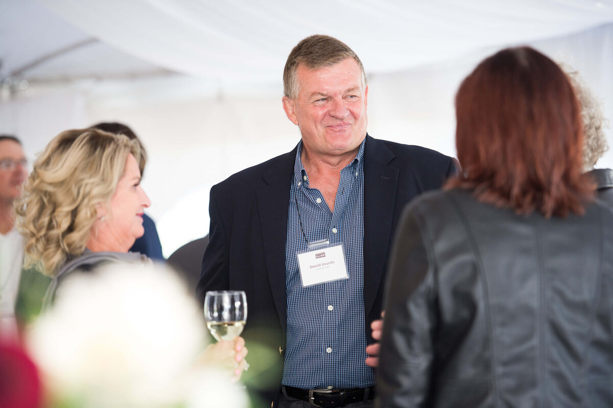 a candid photo of guests mingling at a corporate anniversary celebration.  Captured by Ottawa Event Photographer JEMMAN Photography COMMERCIAL