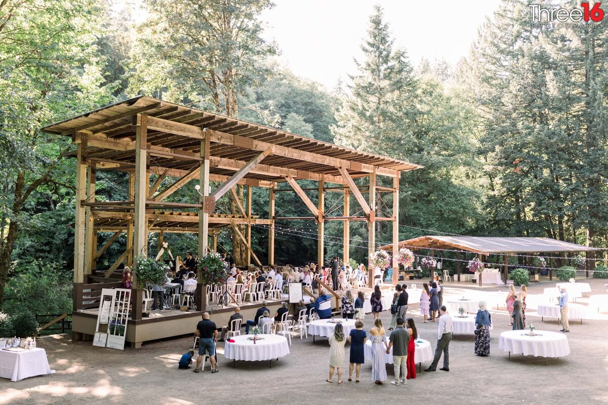 Wedding Ceremony taking place under a large wood stage in the mountains northwest of Portland, OR