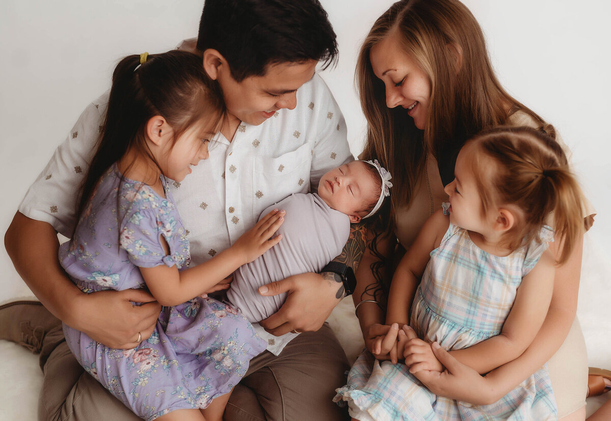 Siblings embrace their baby sister during Newborn Photoshoot in Charleston, SC.