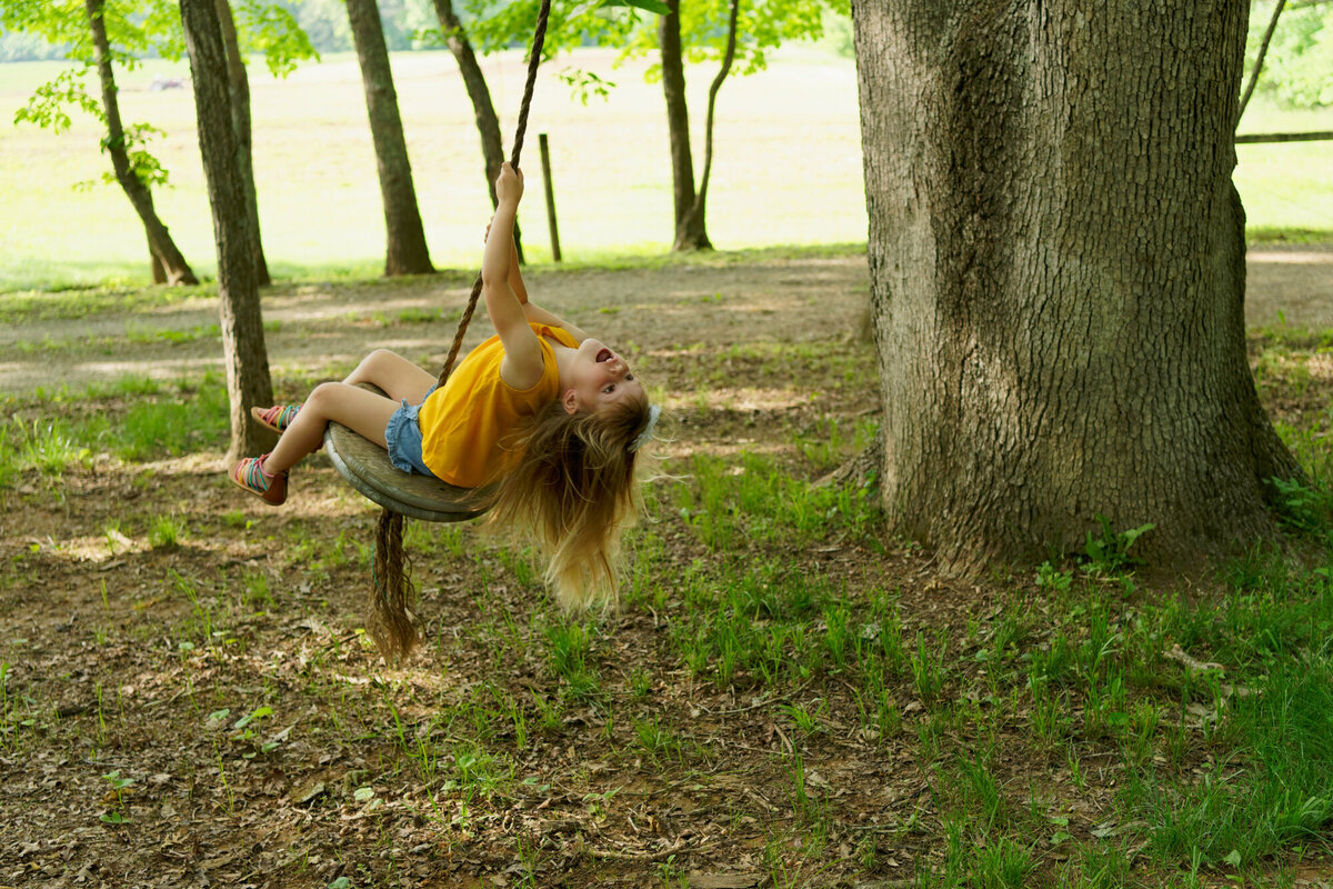 girl swinging outdoor daytime portrait