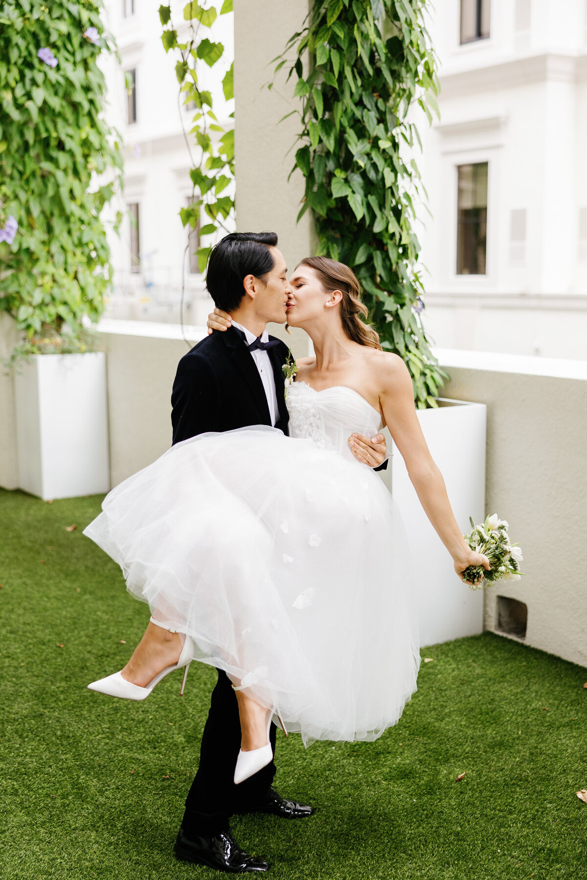 Bride and groom share a kiss while the groom lifts the bride, captured by Claudia Amalia, a wedding and lifestyle photographer based in Miami, Florida. Specializing in destination weddings in South Florida and the Florida Keys.