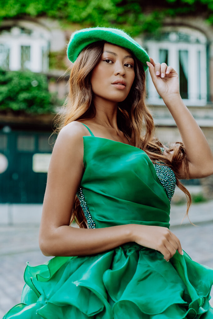 Elegant portrait of Asian woman wearing emerald green princess dress and coordinating beret in Paris