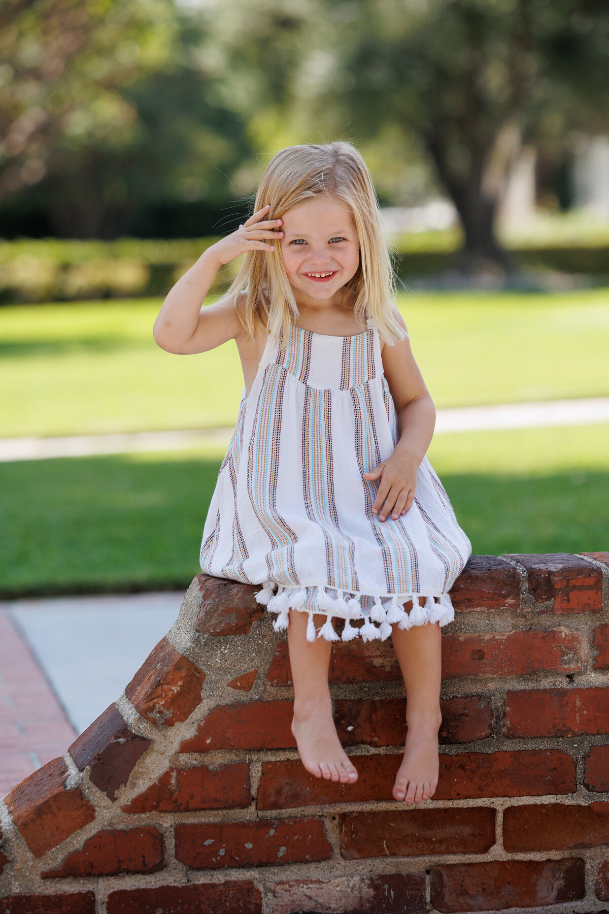 Little girl sitting on a brick wall
