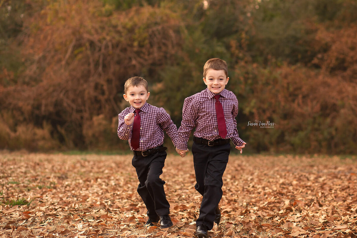 Brothers running through leaves by Susan VanNess Photography, a Raleigh family photographer