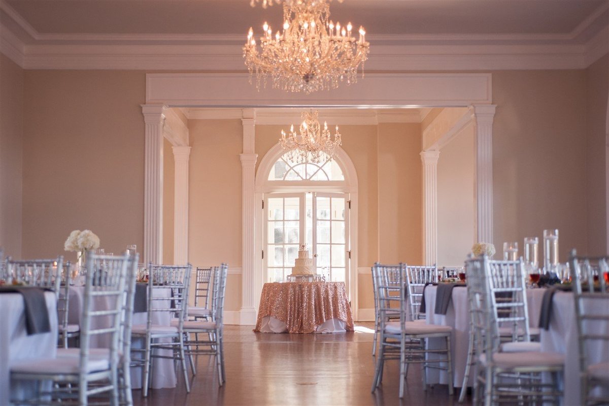 Wedding reception area with cake and chandeliers in Gastonia NC at Separk Mansion by Amanda Lunsford Photography