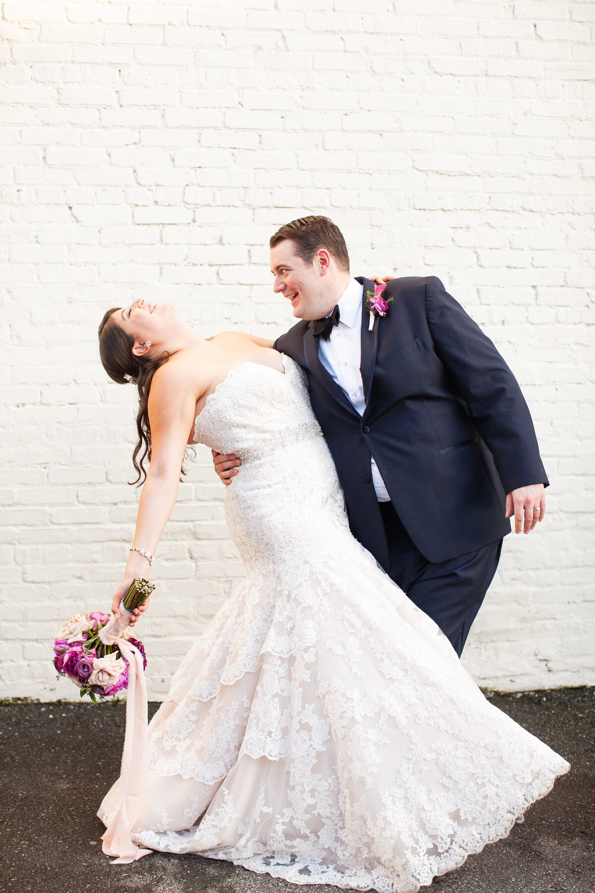 groom-dipping-bride-white-brick