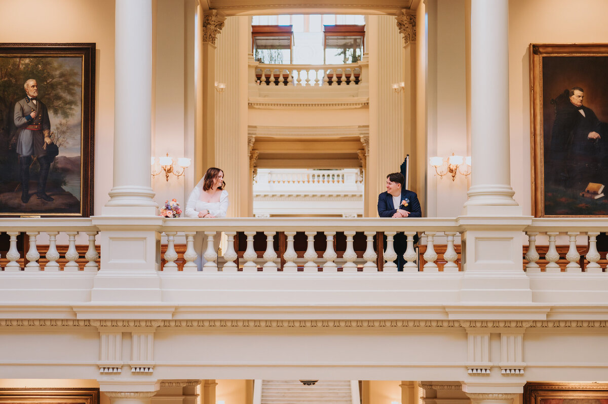 Newlyweds stand next to columns in a courthouse