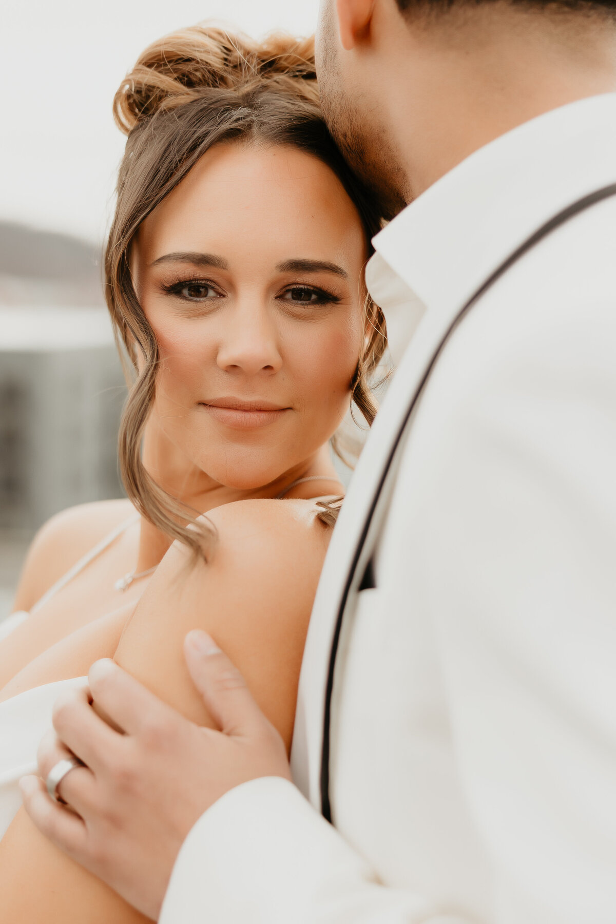 Bride looking at Camera in white out wedding