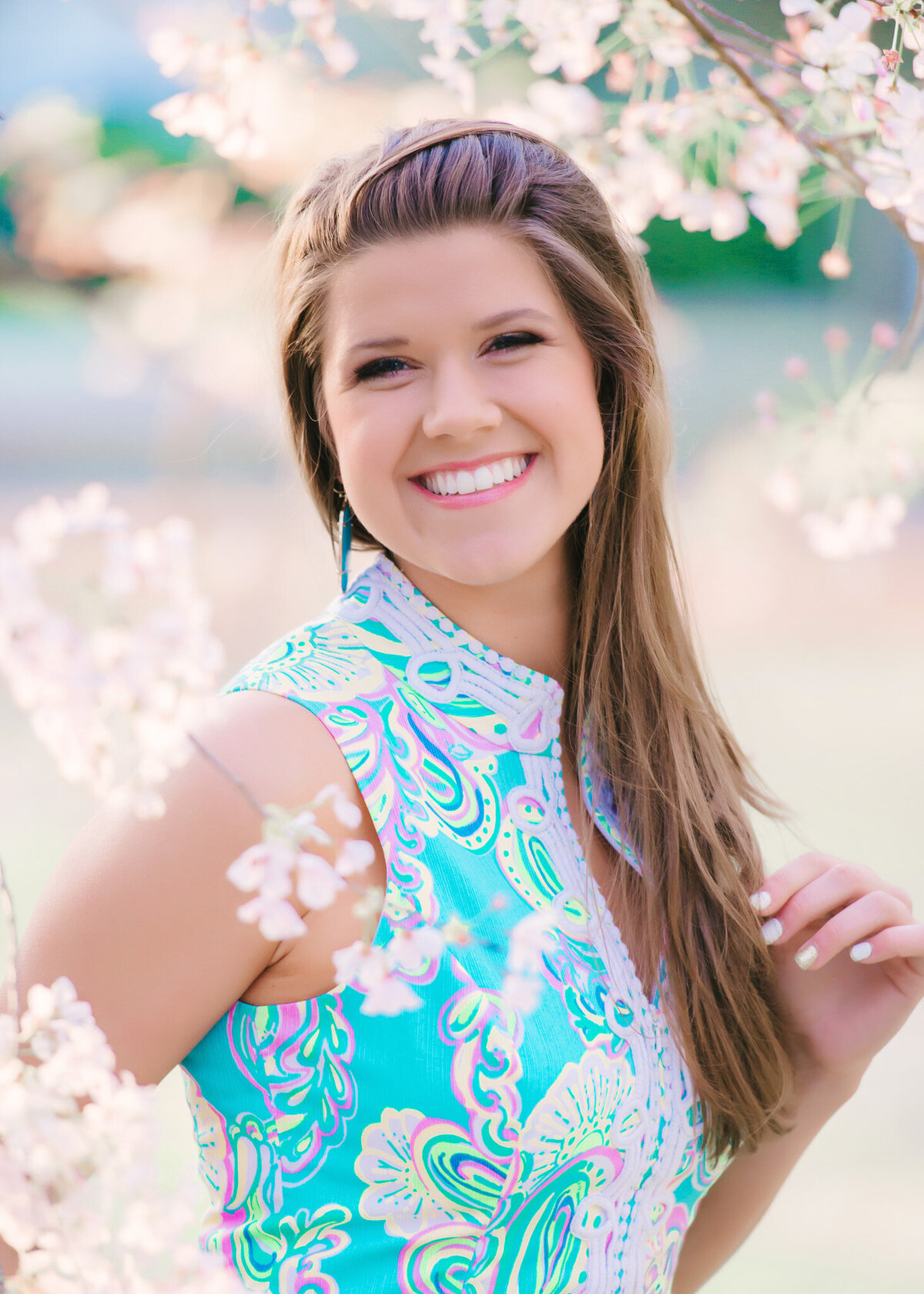 Smiling senior girl in bright blue dress during natural light headshot session in Charleston