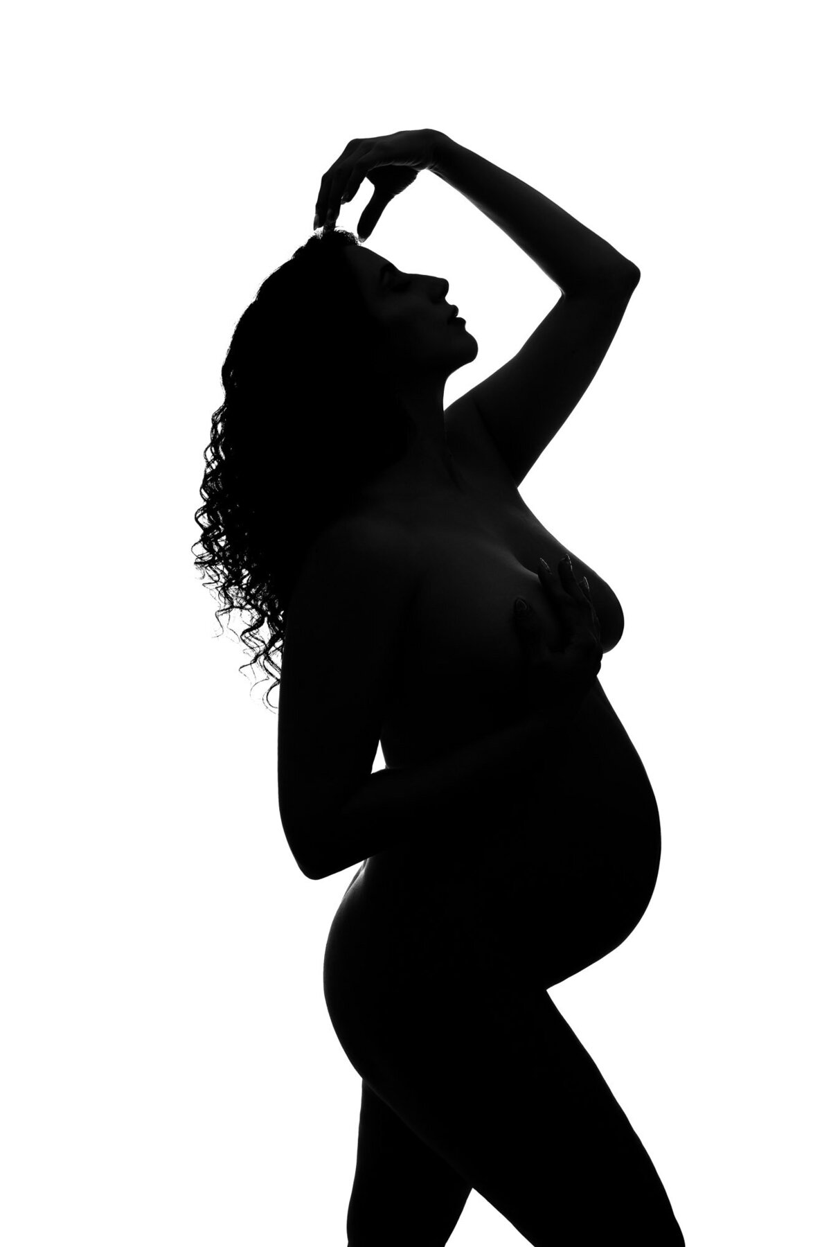 Classic maternity silhouette portrait by Crystal Falls maternity photographer with studio lighting